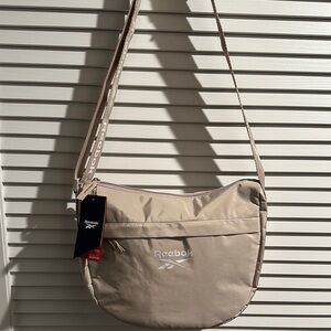 NWT Reebok Women’s Sophie Crossbody/Shoulder Bag with zipper front pocket.